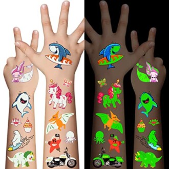 Children's arms with colorful glow-in-the-dark tattoos, including sharks, unicorns, and other playful designs.