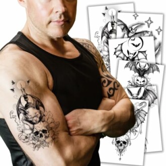 Man with a bat and skull tattoo on his arm, holding tattoo design sheets.